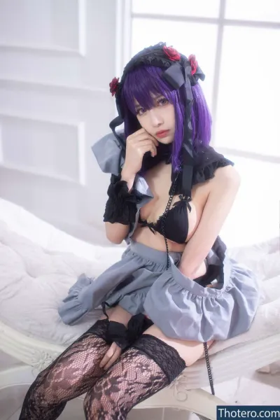 shika.xiaolu_lu - woman in a black and purple outfit sitting on a bed