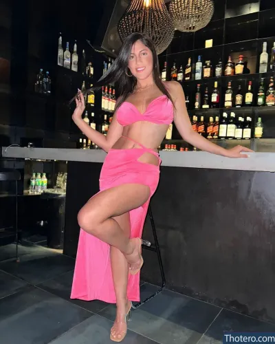 Yarden Ardity - woman in a pink dress posing in front of a bar