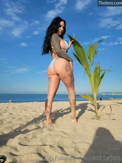 Getin_loser21 - woman in a bikini standing on a beach with a palm tree