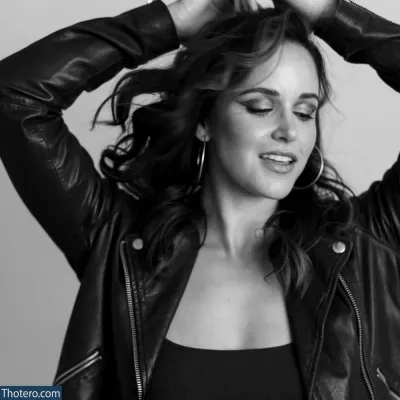 Melissa Fumero - woman in a leather jacket holding her hair up