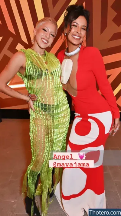 Maya Jama - two women in costumes posing for a picture in front of a wall