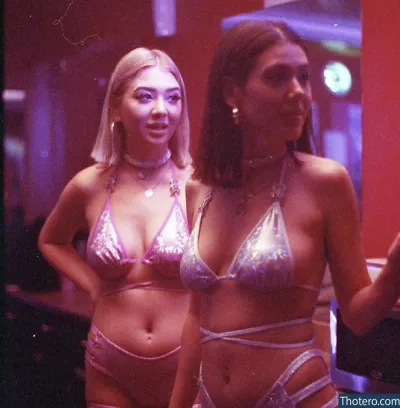 Juno Kawa - two women in bikinis standing in a bar with a mirror