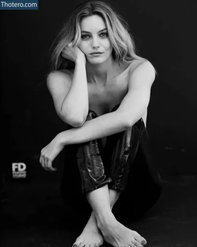 Leila George - a black and white photo of a woman sitting on the ground