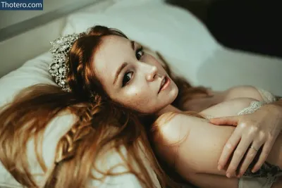 Flávia Sayuri - there is a woman laying on a bed with a tiara on her head