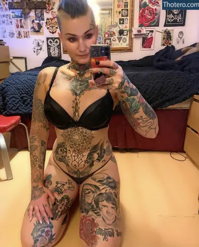 Heather McLean - tattooed woman taking a selfie in a bedroom with a mirror