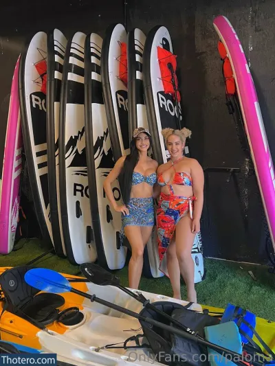 Paloma - there are two women standing next to each other in front of surfboards