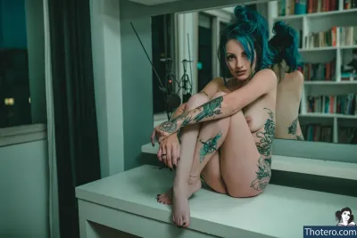 Anaís - there is a woman with blue hair sitting on a counter
