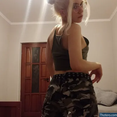 Nasijjj - woman in a camo skirt and glasses standing in a room