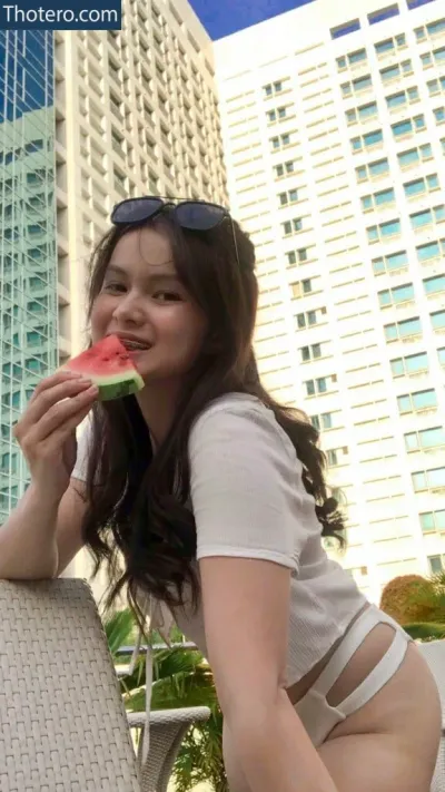 Leysisss - woman in white shirt and sunglasses eating watermelon on a balcony