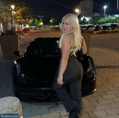 angellbunnyy - in a black dress standing next to a black sports car