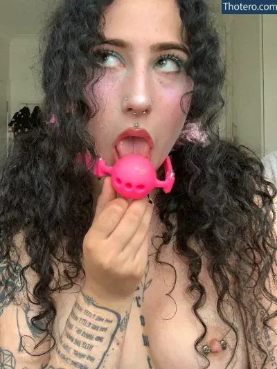 obedientslxt - woman with black hair and piercings holding a pink object