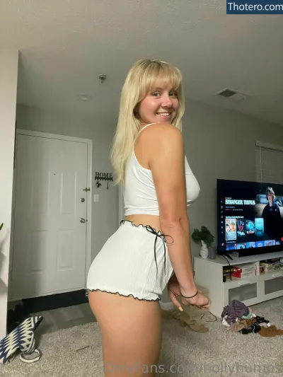 hollyhumps - blonde woman in white shorts and white top standing in front of a television