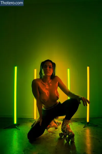 Alyson Eckmann - woman sitting on a skateboard in a green room