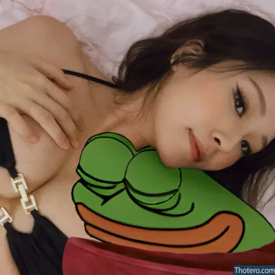 Ya Stacey - woman laying on a bed with a pillow with a frog on it