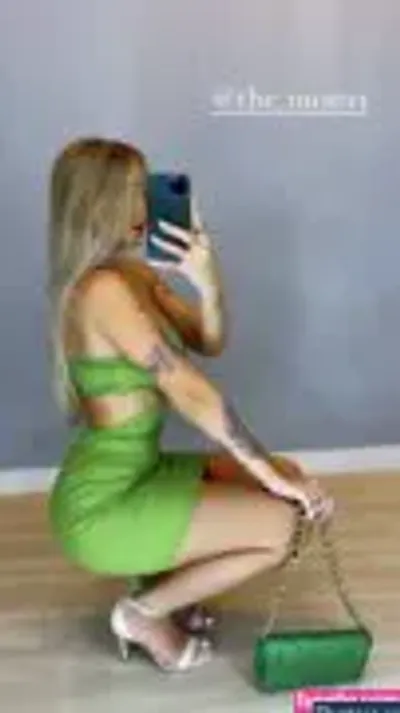 Vitória Mondoni - blonde woman in green dress taking a picture of herself with her cell phone
