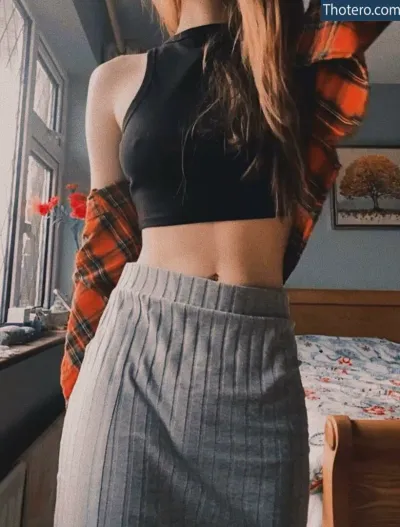 Laura Anne - a close up of a woman in a skirt and a plaid shirt
