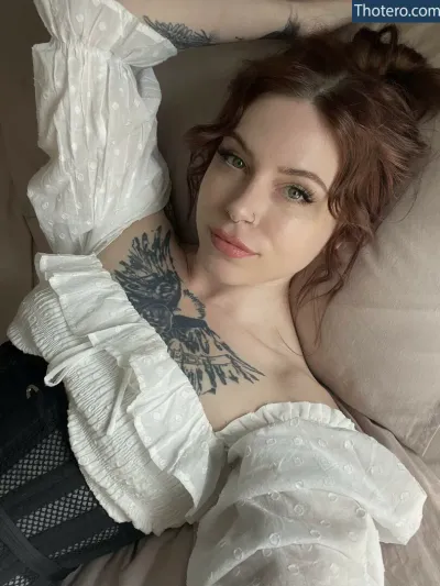 edgarallanxhoe - woman laying on a bed with a tattoo on her chest