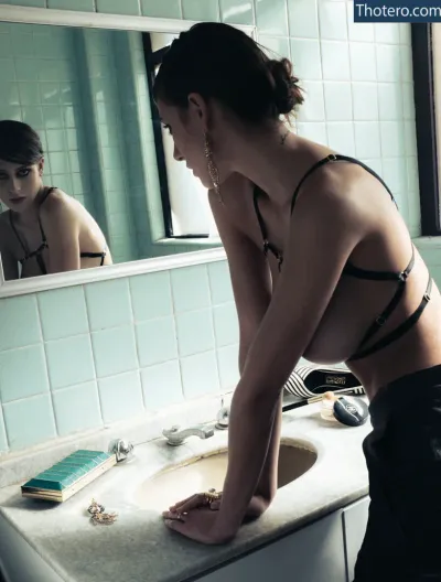Alejandra Guilmant - there is a woman in a bikini washing her hands in a bathroom sink