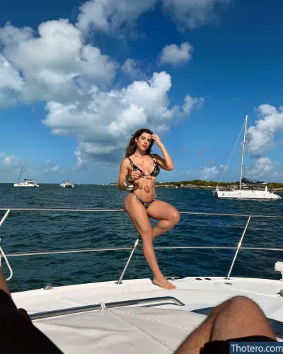 Ana Paula Minerato - woman in a bikini sitting on a boat in the ocean