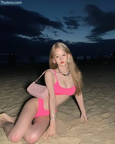 iam666666 - blond woman in pink bikini sitting on the beach at night
