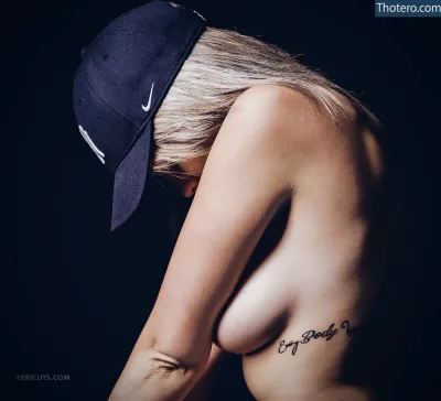 Kinky_kimmie - woman with a hat on her head and a tattoo on her chest