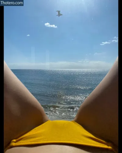 Pom Klementieff - woman in a yellow bikini laying on the beach