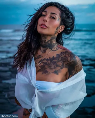 RyderxBurton - a woman with tattoos on her chest and chest standing on the beach