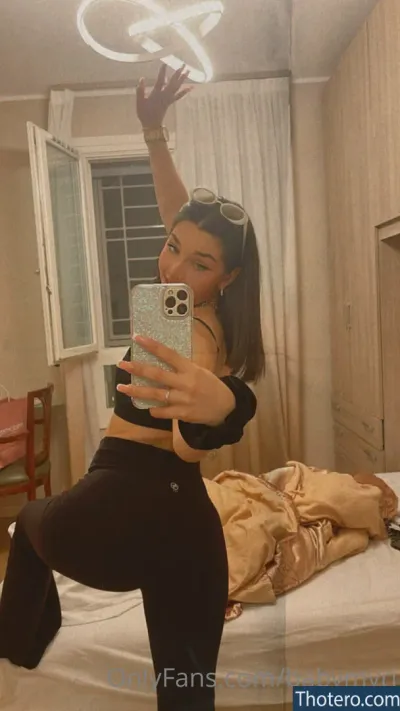 Myriam Sava - woman taking a selfie in a mirror in a bedroom