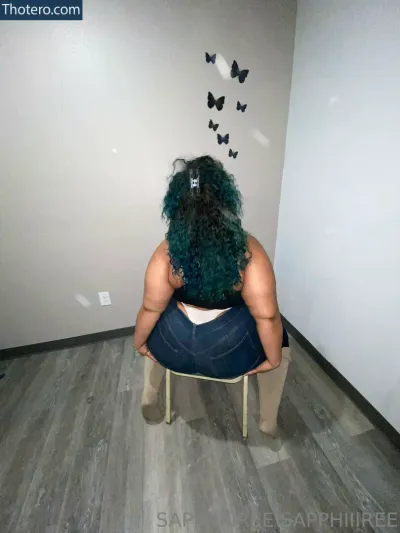 sapphiiireee - sitting on a chair with a butterfly wall behind her