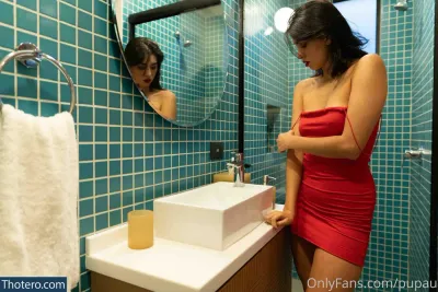 pupau - there is a woman in a red dress standing in front of a sink