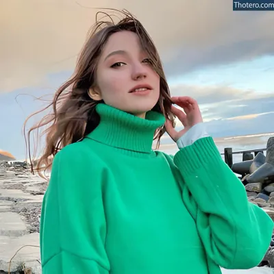 mia_elfie - woman in green turtle neck sweater standing on beach