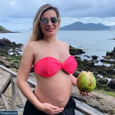 Andressa Urach - pregnant woman in a pink bikini holding a coconut and a drink