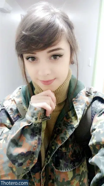 Apricot - a close up of a woman in a camouflage jacket posing for a picture
