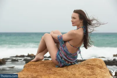 Janeth Tense - woman sitting on a rock near the ocean