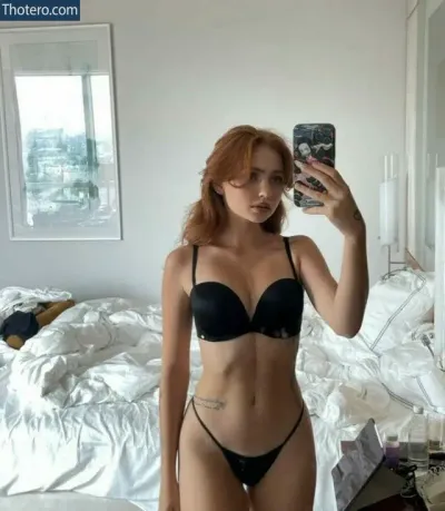Manifest Mag - woman in a black bra top taking a selfie in a bedroom