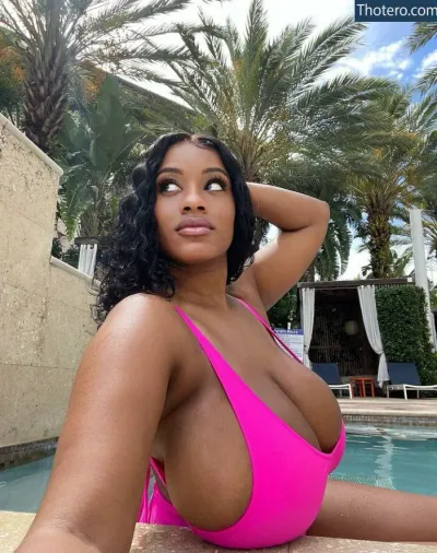 Yanithebbody1 - a woman in a pink bikini sitting next to a pool