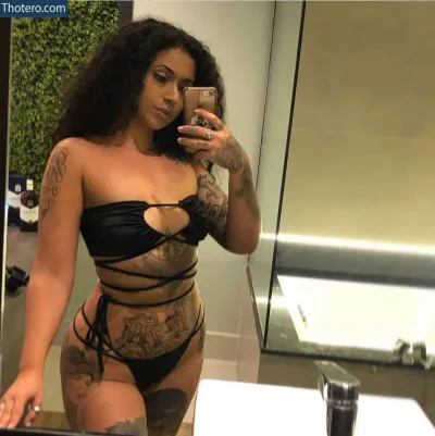 Kristen Kihara - woman in a black bikini taking a selfie in a bathroom mirror