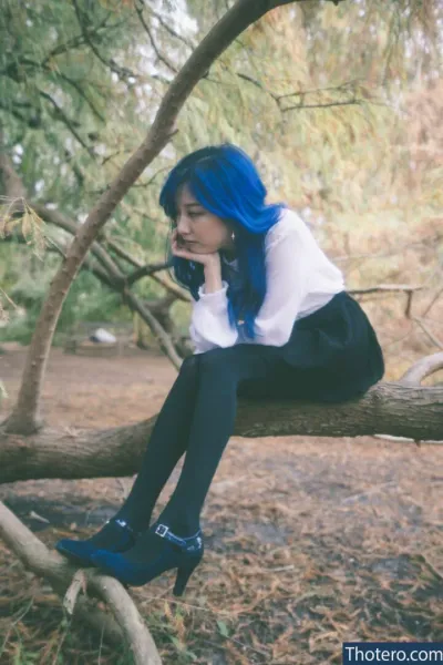 Starsmitten Celine - woman with blue hair sitting on a tree branch