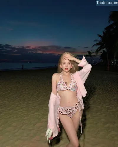 iam666666 - blond woman in a pink bikini and pink jacket on a beach