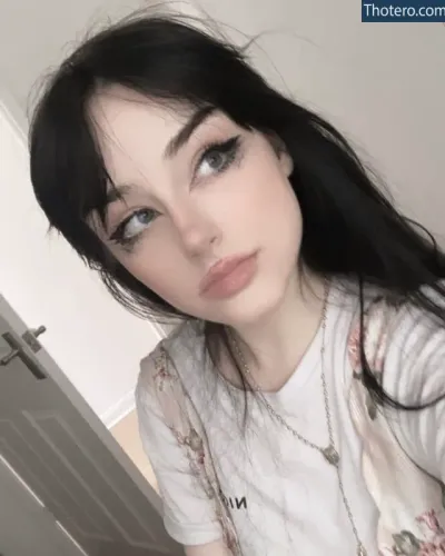 Darkbabybrat - a close up of a woman with long black hair and a white shirt