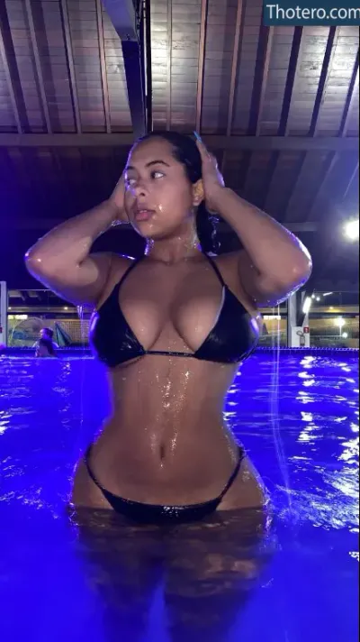 Vitoria Oliveira - a woman in a bikini is standing in a pool