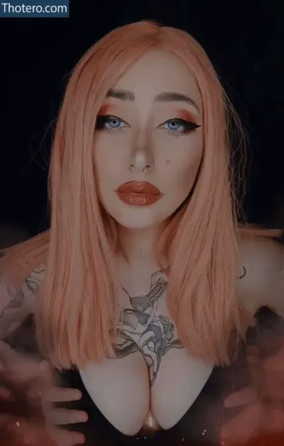 Evolet Asmr - a woman with pink hair and tattoos posing for a picture