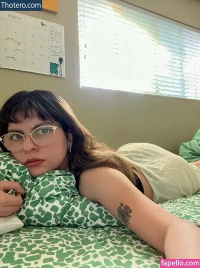 Wide Eyes - woman laying on bed with green and white patterned comforter