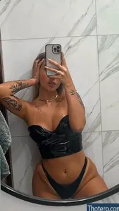 Vitória Mondoni - woman taking a selfie in a bathroom mirror with a towel