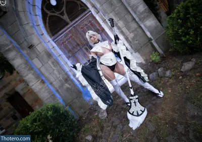 Christine Usi - woman in white dress and black boots standing in front of a castle door