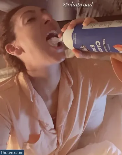 Luisa Zissman - woman in a bathrobe drinking from a bottle while sitting on a bed