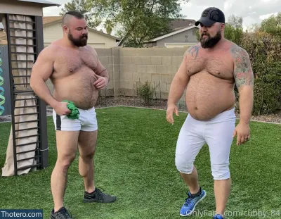 cubby_84 - two men in shorts and hats standing on a grass covered field