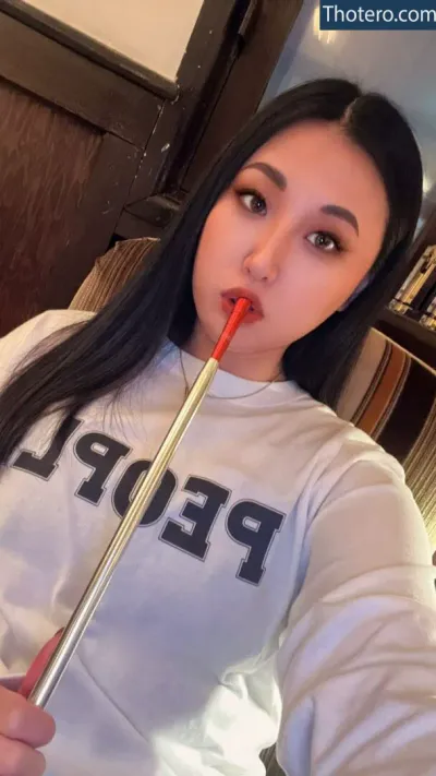 Yurino Hana - woman with long black hair holding a red toothbrush in her mouth