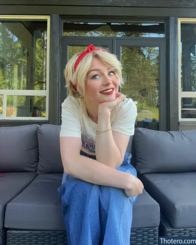KallMeKris - blonde woman sitting on a couch with a red headband