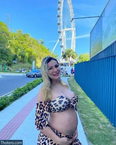 Andressa Urach - pregnant woman in leopard print dress standing in front of a ferris wheel